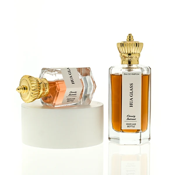 HUA0451 perfume bottle features a clear hexagonal glass body paired with an ornate crown-shaped plastic cap in gold or silver. Designed for wholesalers, it offers 50ml and 100ml choices, combining a regal aesthetic with structural durability for diverse fragrance lines.