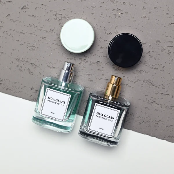 HUA0452 perfume bottle features a clear rounded square glass body paired with a smooth, thick cylindrical plastic cap. Designed for wholesalers, it offers 30ml, 50ml, and 100ml capacity options, combining an elegant minimalist design with functional durability.