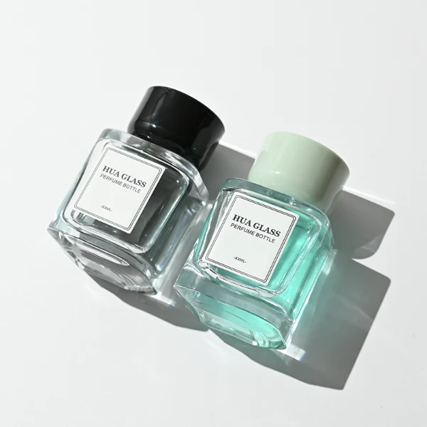HUA0452 perfume bottle features a clear rounded square glass body paired with a smooth, thick cylindrical plastic cap. Designed for wholesalers, it offers 30ml, 50ml, and 100ml capacity options, combining an elegant minimalist design with functional durability.