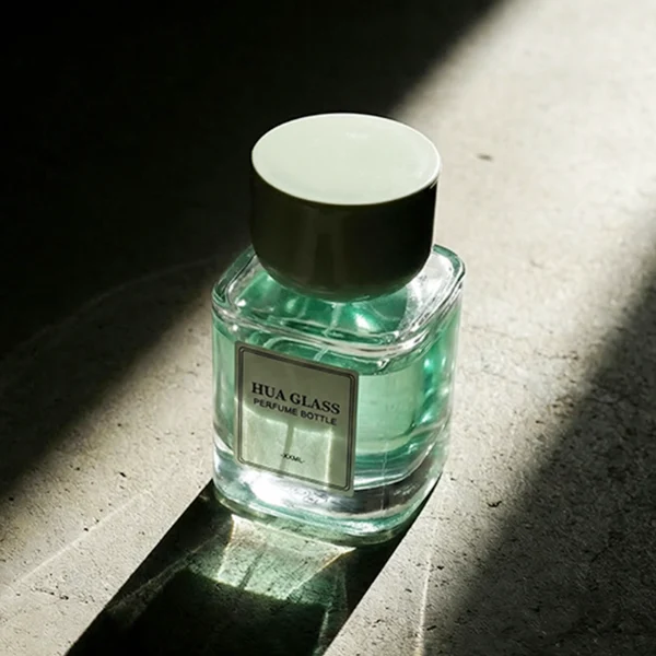 HUA0452 perfume bottle features a clear rounded square glass body paired with a smooth, thick cylindrical plastic cap. Designed for wholesalers, it offers 30ml, 50ml, and 100ml capacity options, combining an elegant minimalist design with functional durability.