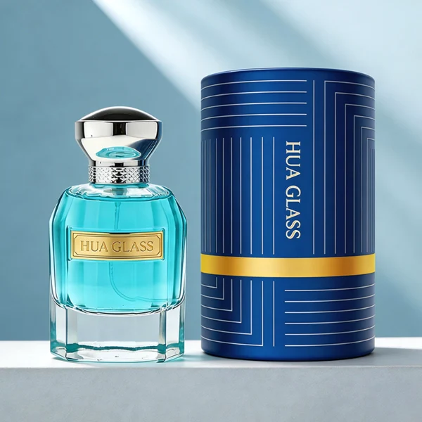 In the provided image, two clear Cylindrical glass perfume bottles with thick bases stand side by side, containing light blue and amber liquids. The left bottle is topped with a smooth, flared silver cap with a textured collar, while the right bottle is topped with a unique, textured wavy black cap.