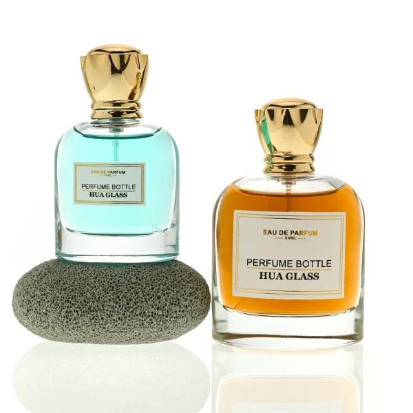 HUA0456 perfume bottle features a rounded, curved clear glass body paired with a unique crown-like glossy golden plastic cap. Designed for wholesalers, it offers 50ml and 100ml capacity options, combining an elegant silhouette with practical durability.