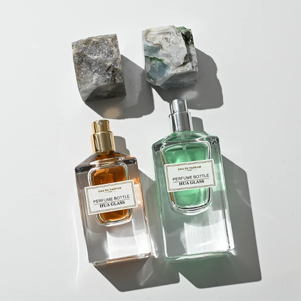 HUA0457 perfume bottle showcases a clear, thick-bottomed rectangular glass frame paired with a striking, unique block cap made of raw natural stone. Designed for premium wholesale markets, it offers 30ml and 50ml options, combining an organic elemental style with architectural structural durability.