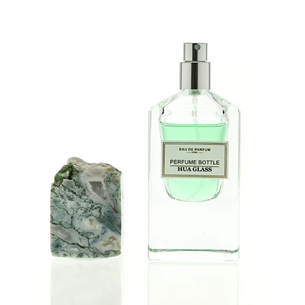 HUA0457 perfume bottle showcases a clear, thick-bottomed rectangular glass frame paired with a striking, unique block cap made of raw natural stone. Designed for premium wholesale markets, it offers 30ml and 50ml options, combining an organic elemental style with architectural structural durability.