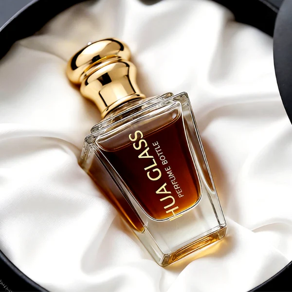 HUA0459 perfume bottle, features an architectural, angular clear glass body with a tapered silhouette, paired with a heavy metallic crown-shaped Zamac cap. Designed for luxury wholesalers, it offers a 50ml capacity option blending upscale geometric lines with premium durability.