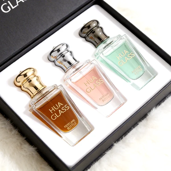 HUA0459 perfume bottle, features an architectural, angular clear glass body with a tapered silhouette, paired with a heavy metallic crown-shaped Zamac cap. Designed for luxury wholesalers, it offers a 50ml capacity option blending upscale geometric lines with premium durability.