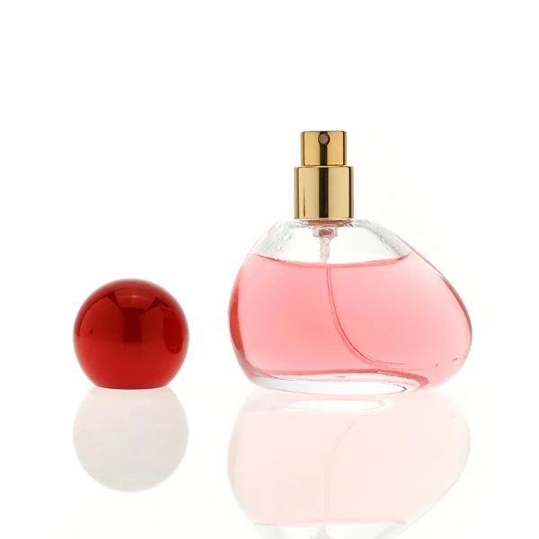 HUA0460 perfume bottle features an asymmetrical, organic pebble-shaped clear glass body paired with a glossy spherical ball cap in blue, red, or pink, it offers a 50ml capacity option, blending a playful geometric profile with high wholesale utility.