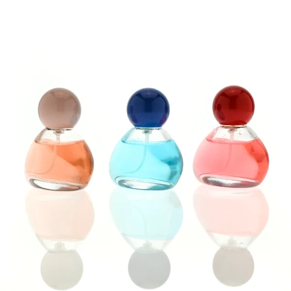 HUA0460 perfume bottle features an asymmetrical, organic pebble-shaped clear glass body paired with a glossy spherical ball cap in blue, red, or pink, it offers a 50ml capacity option, blending a playful geometric profile with high wholesale utility.