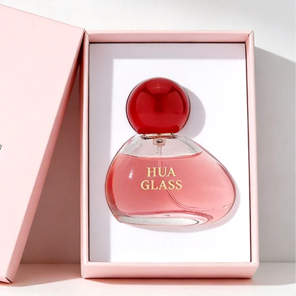 HUA0460 perfume bottle features an asymmetrical, organic pebble-shaped clear glass body paired with a glossy spherical ball cap in blue, red, or pink, it offers a 50ml capacity option, blending a playful geometric profile with high wholesale utility.