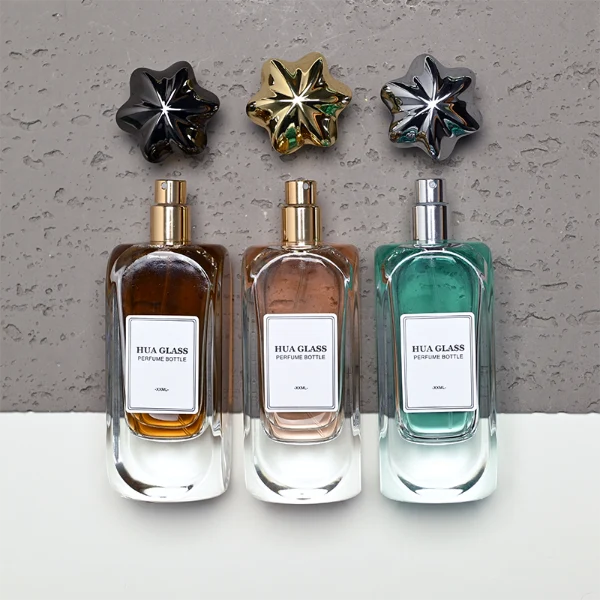 A luxury rectangular perfume bottle featuring a thick, rounded clear glass base and a heavy metallic crown-shaped Zamac cap in gold, silver, or black.
