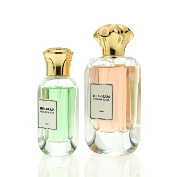 A luxury rectangular perfume bottle featuring a thick, rounded clear glass base and a heavy metallic crown-shaped Zamac cap in gold, silver, or black.