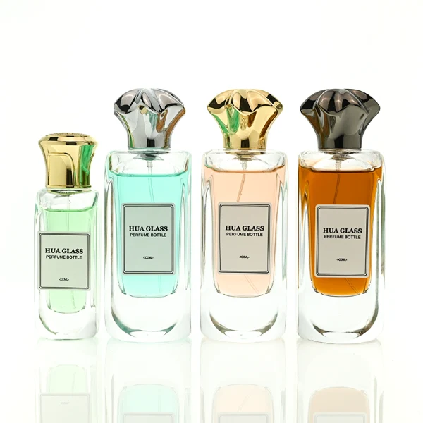 A luxury rectangular perfume bottle featuring a thick, rounded clear glass base and a heavy metallic crown-shaped Zamac cap in gold, silver, or black.