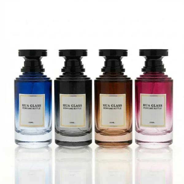 A thick-bottomed cylindrical glass perfume bottle featuring a round, curved profile with gradient color finish choices like black, blue, pink, or brown, topped with a uniquely styled injection-molded plastic cap in black or white.