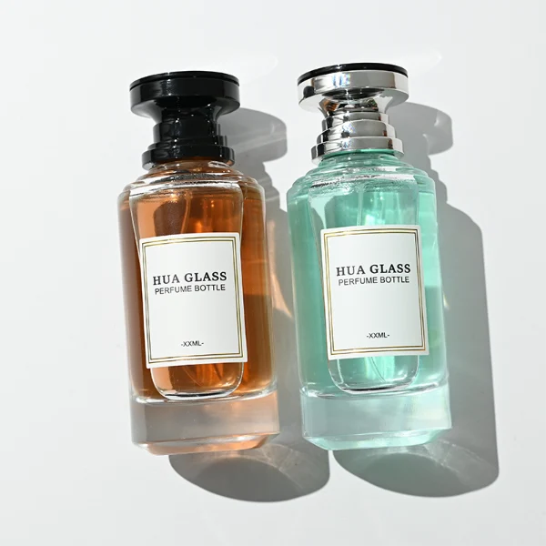 A thick-bottomed cylindrical glass perfume bottle featuring a round, curved profile with gradient color finish choices like black, blue, pink, or brown, topped with a uniquely styled injection-molded plastic cap in black or white.