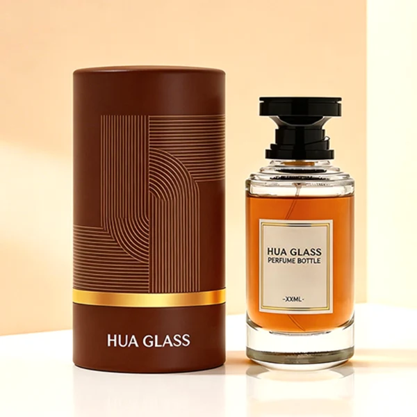 A thick-bottomed cylindrical glass perfume bottle featuring a round, curved profile with gradient color finish choices like black, blue, pink, or brown, topped with a uniquely styled injection-molded plastic cap in black or white.