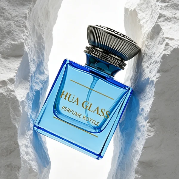 A thick-bottomed cube glass perfume bottle featuring an angular, square silhouette with semi-translucent or frosted colored finishes, topped with a heavy, uniquely ribbed metallic Zamac cap available in black, gold, or silver.