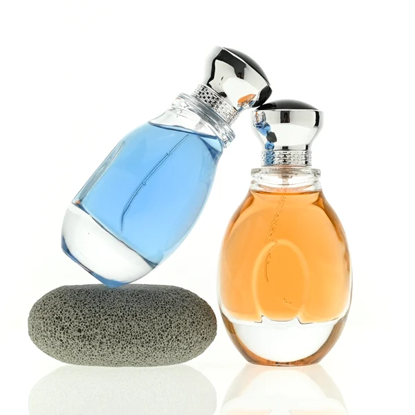 A 100ml clear glass perfume bottle with a smooth, globular curved profile and a thick base. The neck features a detailed metallic collar paired with a silver crown-motif cap topped with a dark glossy insert.