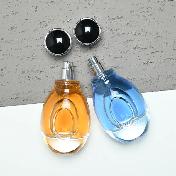 A 100ml clear glass perfume bottle with a smooth, globular curved profile and a thick base. The neck features a detailed metallic collar paired with a silver crown-motif cap topped with a dark glossy insert.