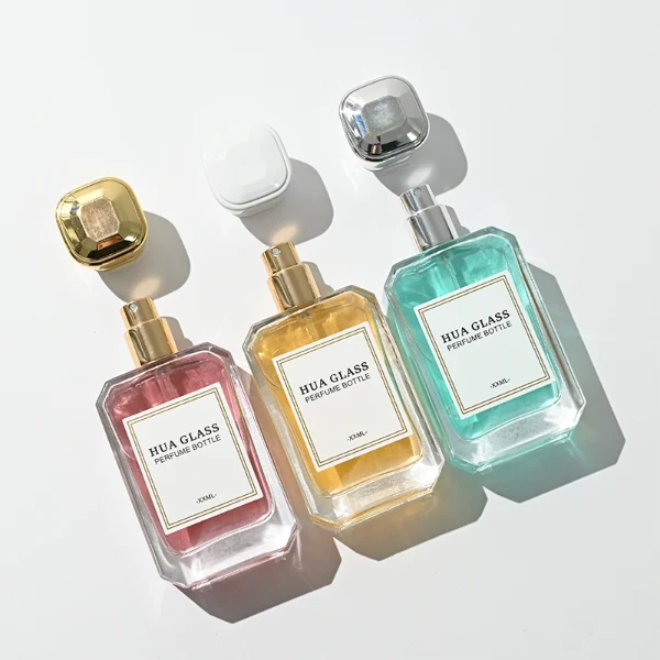 A diamond-cut rectangular glass perfume bottle with a clear, angular profile and an elegant faceted border, paired with a smooth, trapezoidal square plastic cap available in gold, silver, or matte white.