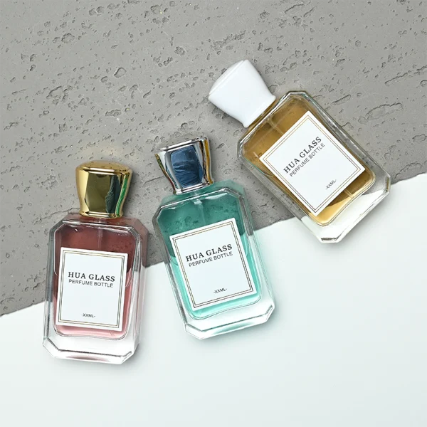 A diamond-cut rectangular glass perfume bottle with a clear, angular profile and an elegant faceted border, paired with a smooth, trapezoidal square plastic cap available in gold, silver, or matte white.