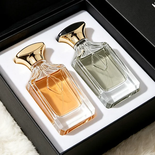 A diamond-cut rectangular clear glass perfume bottle with faceted corners and textured vertical ridges along the upper shoulders, paired with a unique flared, curved plastic cap available in solid gold or black-and-gold finish.