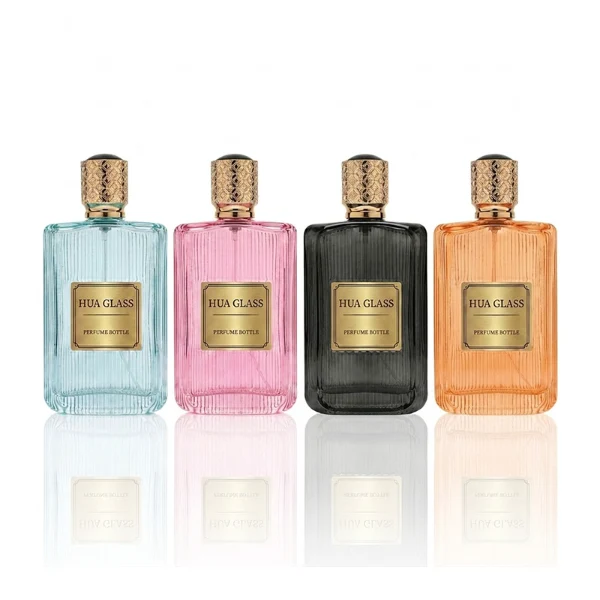 A rectangular clear glass perfume bottle detailed with distinct vertical grooves and a smooth central label indentation, paired with a cylindrical golden plastic cap featuring an intricate textured pattern.