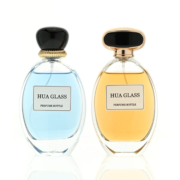 a globular curved clear glass perfume bottle features an oval silhouette with a heavy base, paired with a smooth, pebble-shaped plastic cap available in glossy solid black with a ribbed gold collar, or a flat-oval black design encased in a gold border.