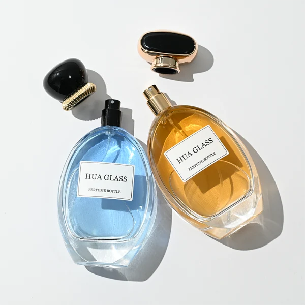 a globular curved clear glass perfume bottle features an oval silhouette with a heavy base, paired with a smooth, pebble-shaped plastic cap available in glossy solid black with a ribbed gold collar, or a flat-oval black design encased in a gold border.