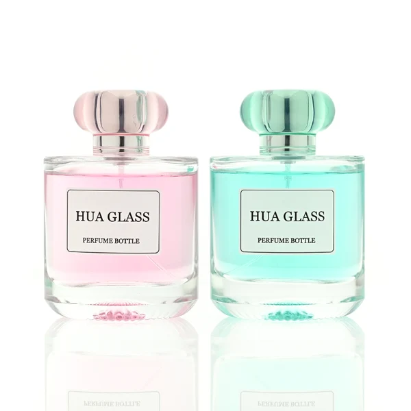 Based on the text description for image_128ca8.png, a clear square glass perfume bottle features rounded shoulders and a substantial, thick glass base, paired with a uniquely styled plastic cap available in pink-and-silver or blue-and-silver accents.