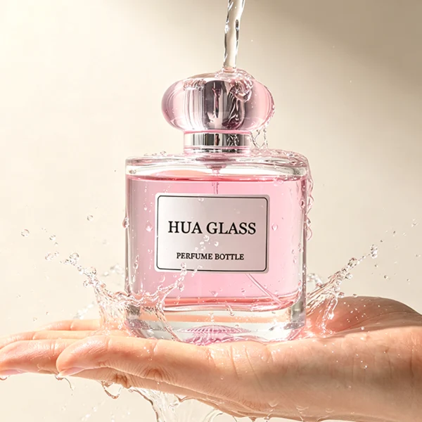 Based on the text description for image_128ca8.png, a clear square glass perfume bottle features rounded shoulders and a substantial, thick glass base, paired with a uniquely styled plastic cap available in pink-and-silver or blue-and-silver accents.