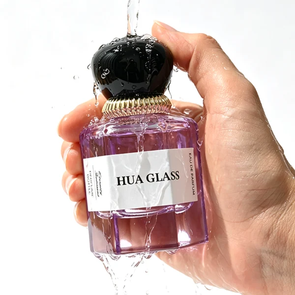 a hexagonal perfume bottle crafted from semi-translucent purple glass features a structured angular silhouette, paired with a pebble cobblestone-shaped plastic cap. The cap is available as either a smooth glossy black or a textured, vertically-ribbed matte white dome, both sitting atop an elegant, braided metallic gold collar.