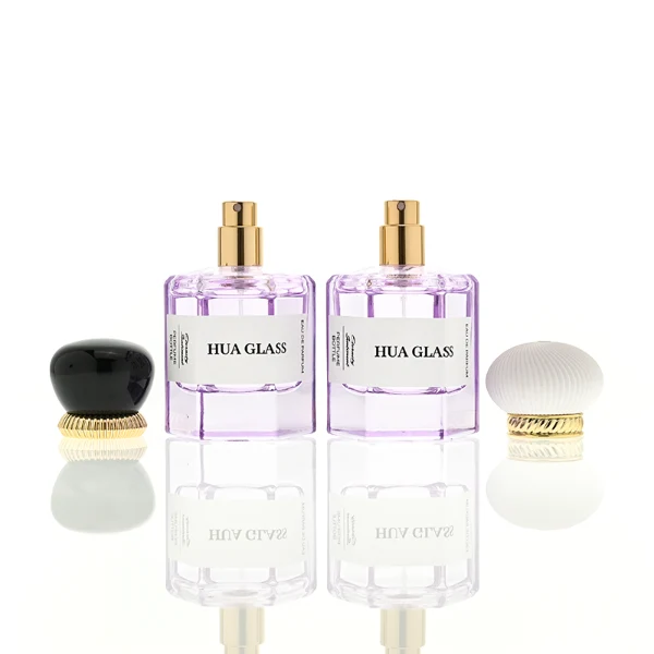 a hexagonal perfume bottle crafted from semi-translucent purple glass features a structured angular silhouette, paired with a pebble cobblestone-shaped plastic cap. The cap is available as either a smooth glossy black or a textured, vertically-ribbed matte white dome, both sitting atop an elegant, braided metallic gold collar.