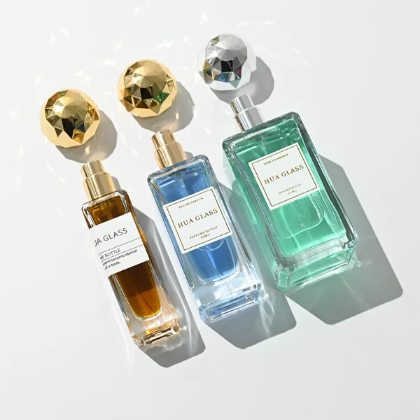 a collection of tall, thick-walled rectangular clear glass perfume bottles in various sizes is paired with a striking, multi-faceted geometric spherical ball cap featuring a disco-ball style design, available in polished metallic gold or silver finishes.