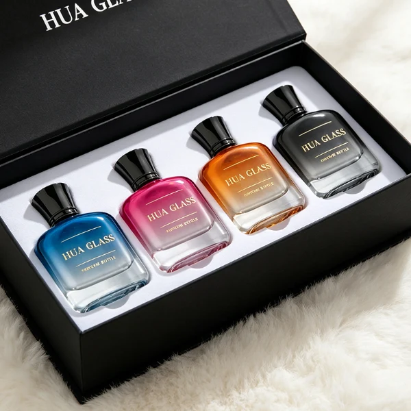 Two smooth rectangular glass perfume bottles with rounded corners and thick clear bases. One features an inner-sprayed metallic silver finish with a gunmetal black multifaceted geometric cap, while the other features an inner-sprayed opaque white finish topped with a chrome silver geometric cap.