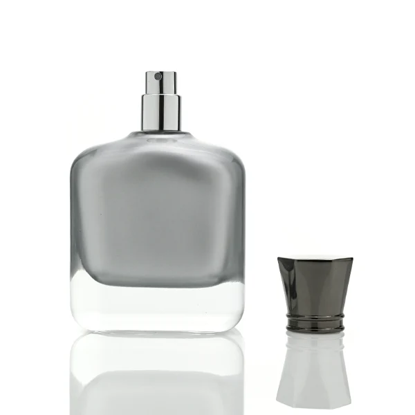 Two smooth rectangular glass perfume bottles with rounded corners and thick clear bases. One features an inner-sprayed metallic silver finish with a gunmetal black multifaceted geometric cap, while the other features an inner-sprayed opaque white finish topped with a chrome silver geometric cap.