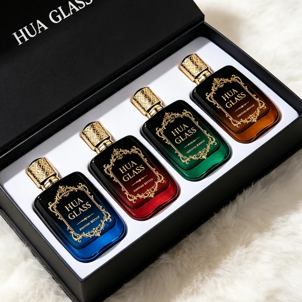 Three flat rectangular perfume bottles with rounded corners are shown in a row. The bottles feature semi-translucent glass bodies in soft grey-blue, delicate pink, and a dark amber-to-black gradient. Each is paired with a cylindrical rose-gold cap detailed with an intricate engraved geometric pattern and capped with a smooth, domed insert on top.