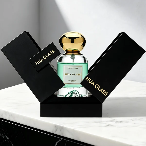 Two cylindrical clear glass perfume bottles filled with amber and light green liquids, featuring a unique, thick base internally sculpted into a mountain peak design. The bottles are paired with smooth, oversized pebble-shaped bulbous caps shown in glossy black and reflective polished gold finishes.