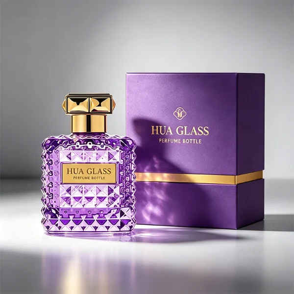 Two square semi-translucent violet glass perfume bottles are shown in 50ml and 100ml sizes, featuring an all-over rockstud-inspired studded diamond texture surrounding a smooth rectangular center panel. Each bottle is topped with a heavy, premium polished golden Zamac square geometric cap with a short cylindrical collar.