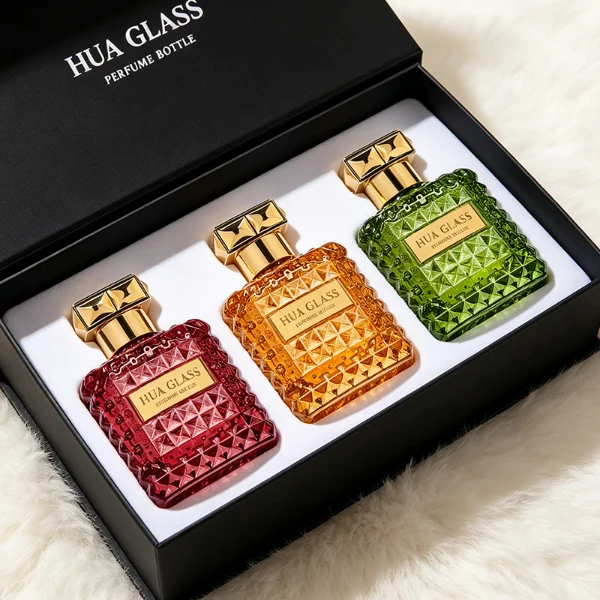 Two square semi-translucent violet glass perfume bottles are shown in 50ml and 100ml sizes, featuring an all-over rockstud-inspired studded diamond texture surrounding a smooth rectangular center panel. Each bottle is topped with a heavy, premium polished golden Zamac square geometric cap with a short cylindrical collar.