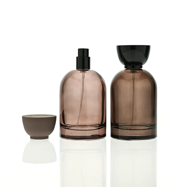 HUA0412 perfume bottle, luxury rounded oval glass bottle with translucent deep multi-color finish in brown, grey, red, or blue, featuring a printed gold logo and a unique glossy black tapered cup-shaped wooden or plastic cap, modern elegant fragrance packaging design available in 30ml, 50ml, and 100ml