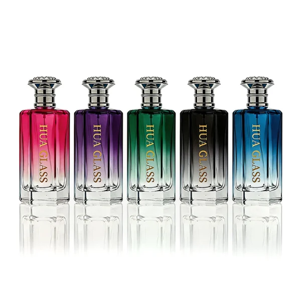 HUA0439 perfume bottle, luxury heavy-base polyhedral angular glass bottle with translucent deep multi-color gradient finish, featuring a crown-shaped flared hourglass solid Zamak cap with an intricately sculpted silver-colored glossy metallic finish, modern elegant fragrance packaging design available in 50ml and 100ml