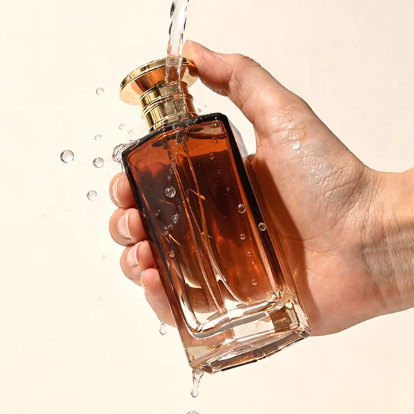 HUA0439 perfume bottle, luxury heavy-base polyhedral angular glass bottle with translucent deep multi-color gradient finish, featuring a crown-shaped flared hourglass solid Zamak cap with an intricately sculpted silver-colored glossy metallic finish, modern elegant fragrance packaging design available in 50ml and 100ml