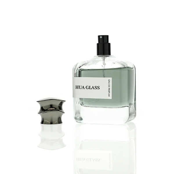 HUA0437 perfume bottle, luxury 100ml heavy-base flat rectangular glass bottle with high-transparency clear finish, featuring a wraparound rectangular paper label and a unique irregular bamboo-joint solid Zamak cap with a mirror-shine glossy metallic finish, modern elegant fragrance packaging design