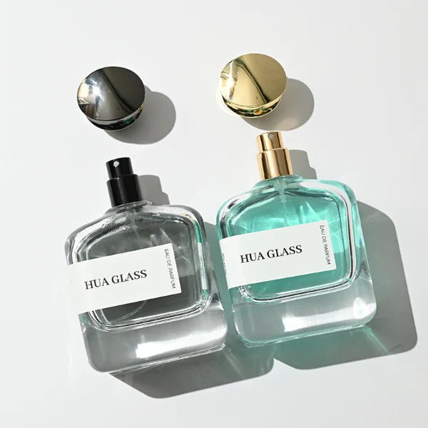 HUA0437 perfume bottle, luxury 100ml heavy-base flat rectangular glass bottle with high-transparency clear finish, featuring a wraparound rectangular paper label and a unique irregular bamboo-joint solid Zamak cap with a mirror-shine glossy metallic finish, modern elegant fragrance packaging design