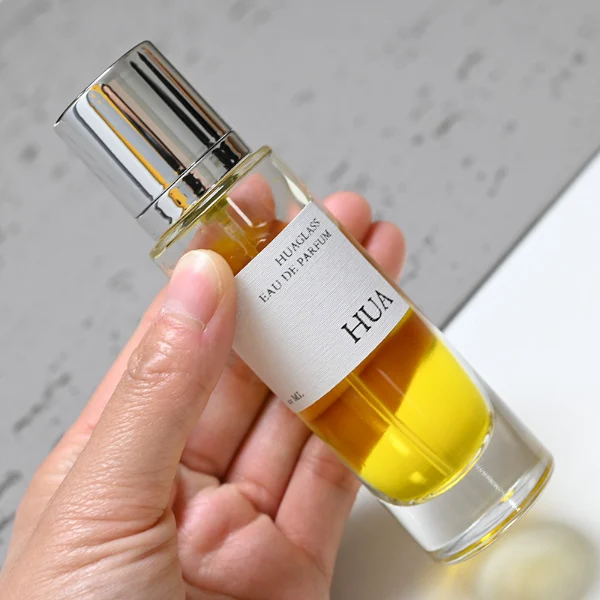 HUA0056 perfume bottle, heavy-base tall slender cylindrical round glass bottle with clear finish, featuring a wide wrapped paper label, a matching neck, and a tall cylindrical plastic cap with a smooth high-gloss shiny finish, elegant modern fragrance packaging design available in 30ml, 50ml, and 100ml