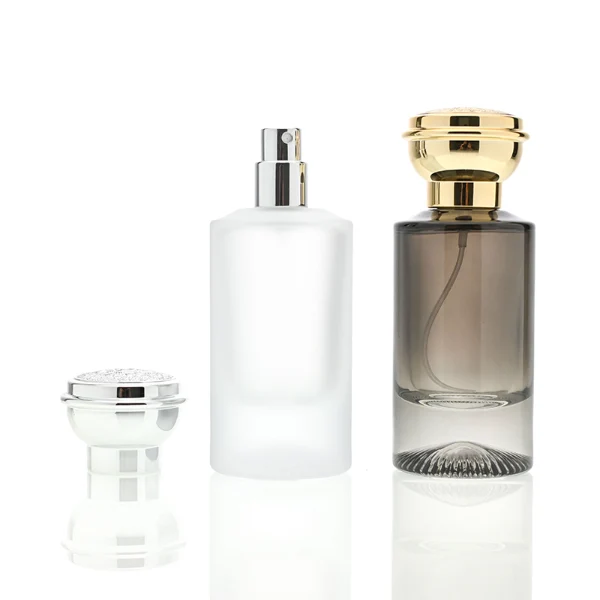 HUA0060 perfume bottle, heavy-base cylindrical round glass bottle with clear finish, featuring a matching neck and an ornate sculptural tiered crown plastic cap with a smooth high-gloss shiny finish, elegant modern fragrance packaging design available in 30ml, 50ml, and 100ml