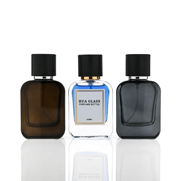 HUA0302 perfume bottle, rounded rectangular glass body with thick base in transparent, semi-transparent black, or amber color, 30 ml, 50 ml, or 100 ml liquid, cylindrical plastic cap with gold or silver bottle neck, printed logo or blank bottle surface, modern minimalist luxury design, ideal for gifting and daily use.