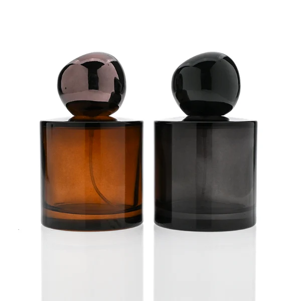 HUA0321 perfume bottle, cylindrical semi-transparent amber or black glass body with thick rounded base, 30 ml, 50 ml, or 100 ml liquid, glossy spherical plastic cap in black or dark purple color, clean blank bottle design, modern artistic minimalist style, ideal for gifting and daily use.