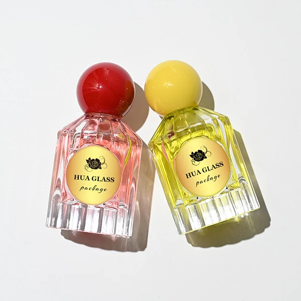 HUA0261 perfume bottle, transparent glass body with radiating cut facets on the upper section and multifaceted cut pattern on the lower section, 50 ml liquid, oversized spherical plastic cap with glossy finish in red or yellow color, gold-tone printed logo label, retro luxury design, ideal for gifting and daily use.