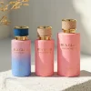 HUA0411 perfume bottle, luxury cylindrical glass bottle with glossy spray colored multi-color finish in pink or pink-blue gradient, featuring a gold-colored collar and a unique textured leather-wrapped plastic cap with gold-colored trim, modern elegant fragrance packaging design available in 30ml, 50ml, and 100ml